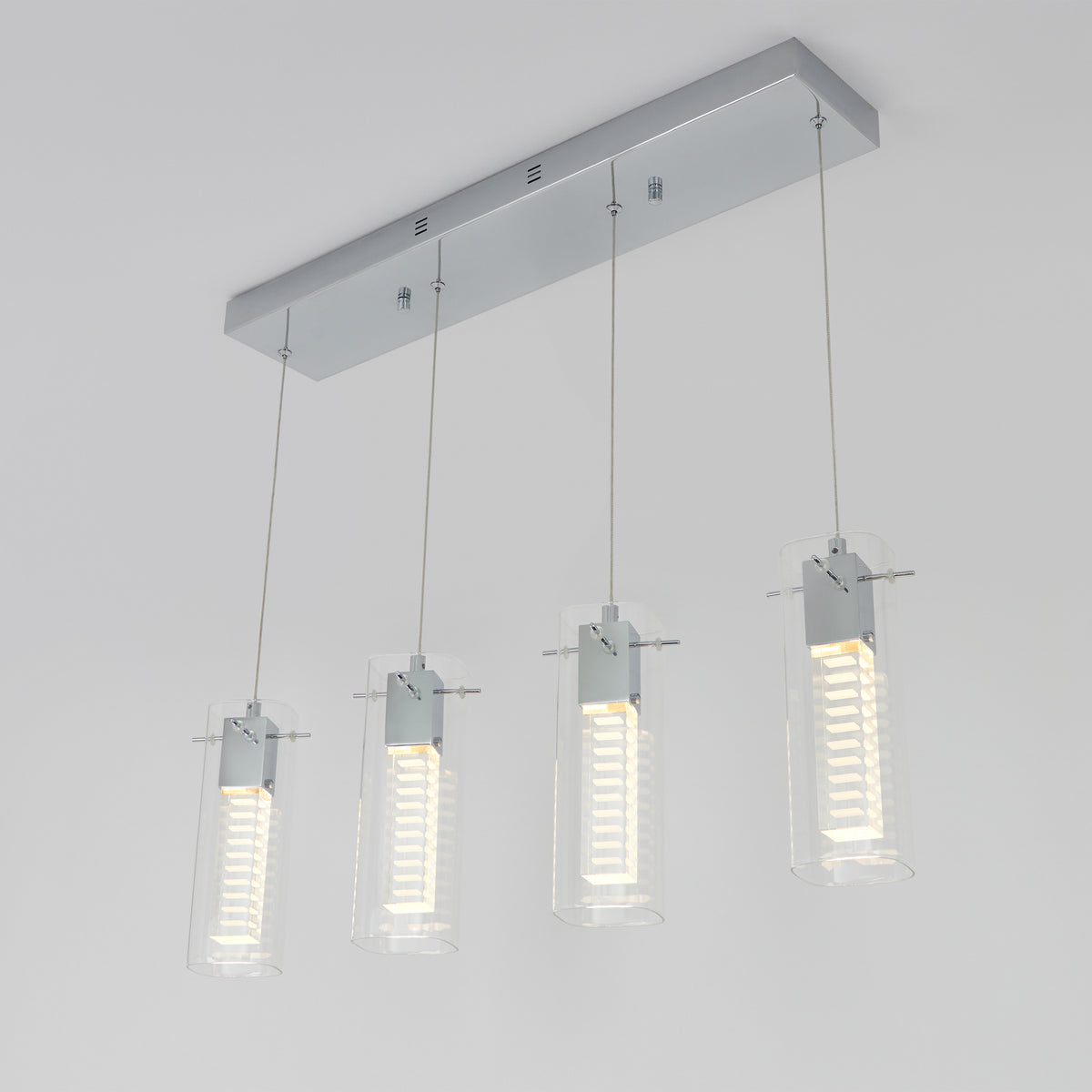 A modern ceiling light fixture with four cylindrical glass pendants, each containing a vertical array of LED lights, hanging from a rectangular chrome base.