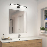 A modern bathroom with a wooden vanity, white countertop, square sink, large wall mirror, sleek black light fixture above the mirror, and a window showing greenery outside.
