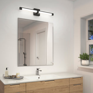 A modern bathroom showcases a large square mirror above a wood vanity with a white countertop, soap dispenser, and tray. Above the mirror is the Artika Tivoli modern LED bathroom vanity light 5 CCT. A window sits to the right.