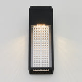 A modern rectangular wall sconce with a black frame and a perforated metallic panel, emitting light from the top and casting subtle patterns on a plain white wall.