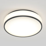 A round, modern ceiling light with a white frosted cover and thin black trim, mounted flush against a white ceiling, emitting a bright, even glow.