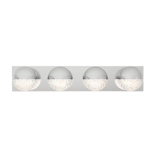 The Artika Carat 27-in (69 cm) Integrated LED Vanity Light Bar for Bathroom features four round, chrome-finish sconces with textured glass bottoms, mounted on a sleek rectangular metallic base.