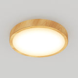 A round ceiling light with a wooden frame and a glowing white diffuser, mounted on a plain white ceiling.