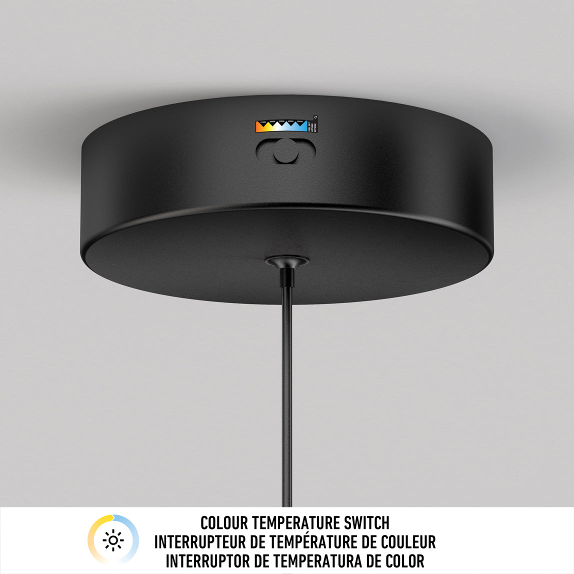 A black ceiling light fixture with a color temperature switch and indicator icons, mounted on a white ceiling. Text below reads: “COLOUR TEMPERATURE SWITCH” in English and French.