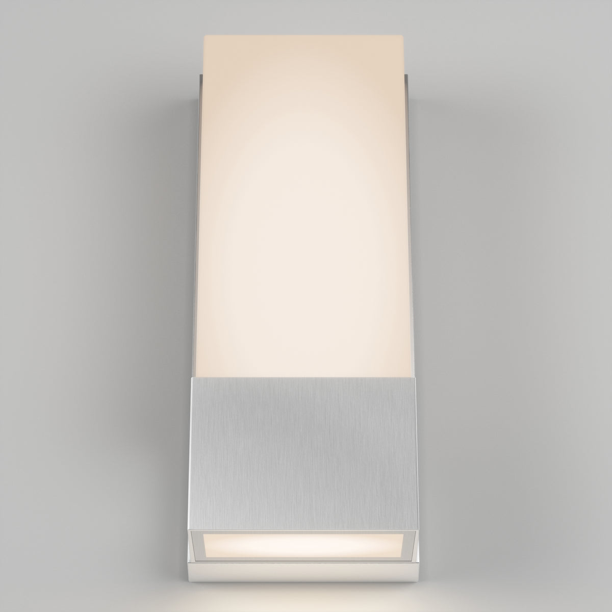 The Artika Dixon indoor-outdoor LED wall light features a brushed metal base and a rectangular frosted glass shade, casting soft, warm light against a light gray background.