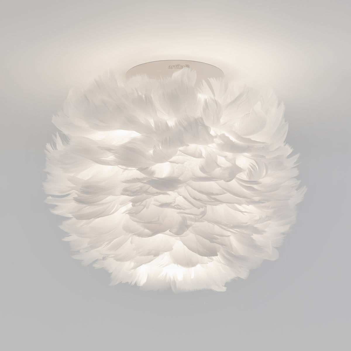 The Artika Plume LED flush mount light features soft white feathers for a fluffy, cloud-like look, making it a unique modern ceiling fixture.