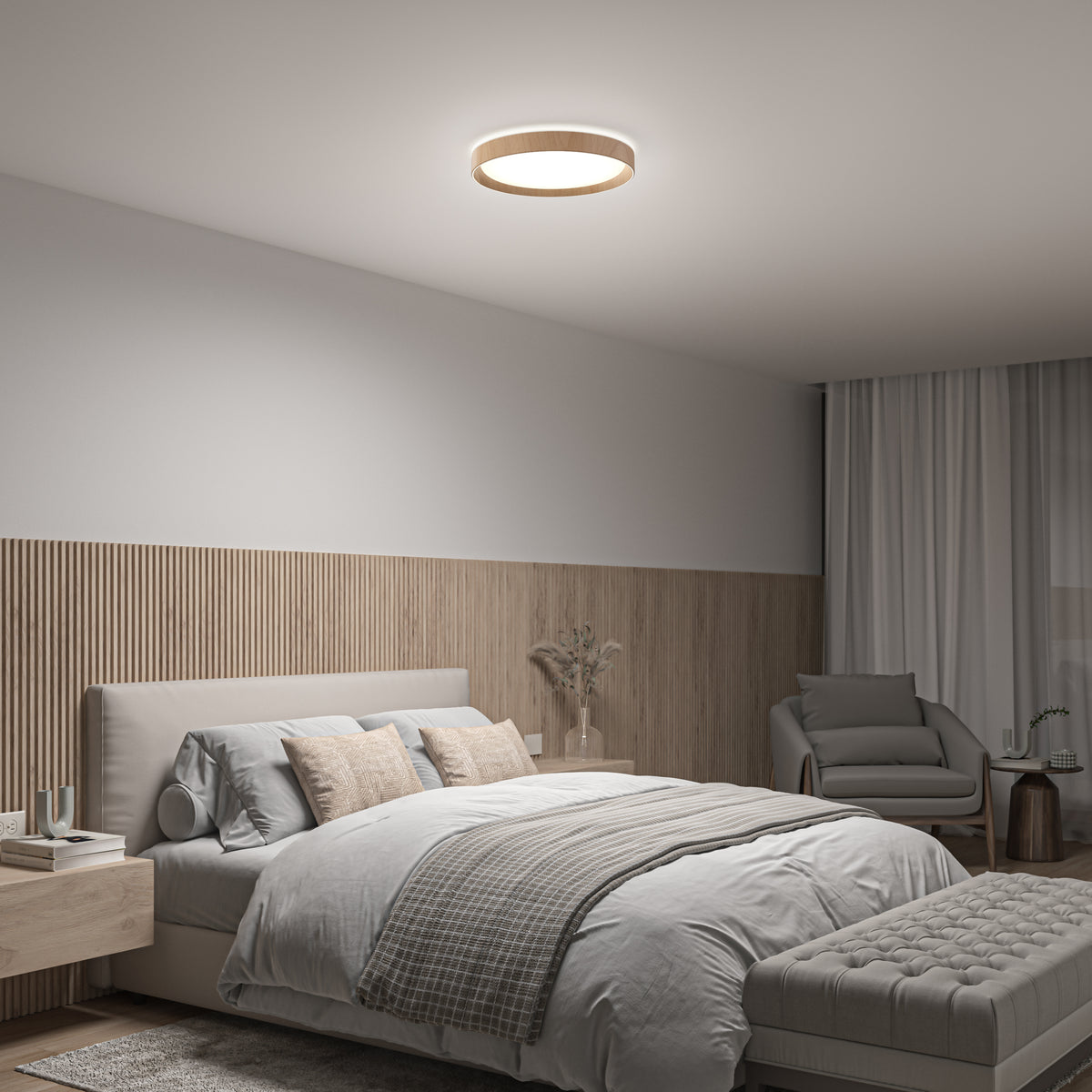 Modern bedroom featuring a large bed with neutral bedding, wooden panel accent wall, armchair, ottoman, side tables, and the Artika Callisto 15 in. LED flush mount light (5 CCT). Soft natural light streams through a window with white curtains.