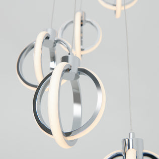 Close-up of the Artika Soho modern 5-light LED pendant, featuring chrome finishes and circular LED rings, suspended by thin wires against a light gray background.