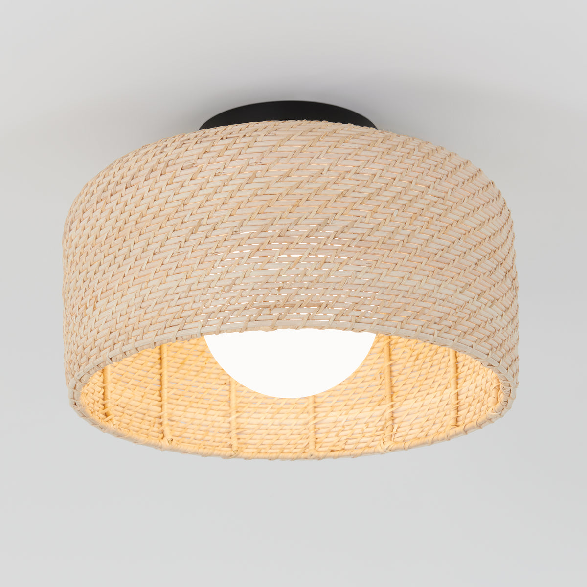 The Emiko modern LED flush mount light by Artika features a woven rattan-style beige shade, a round white bulb, and a black base, creating a contemporary look against any plain white ceiling.