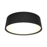 A modern, round black ceiling light fixture with a ribbed texture on the sides and a smooth, glowing white surface underneath.