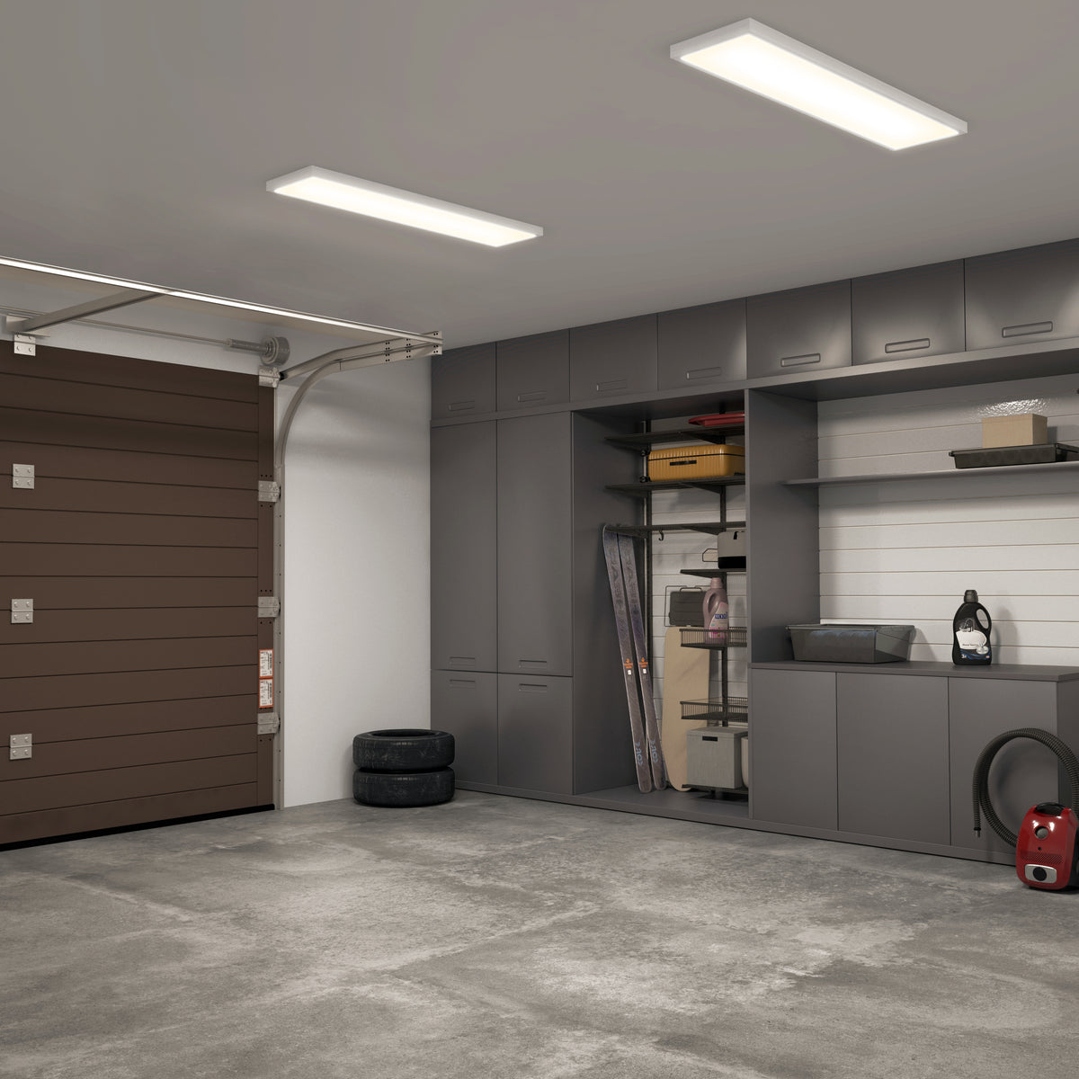 A tidy garage with gray cabinets, shelves, and a brown garage door. Items like tires, storage bins, a toolbox, and a vacuum are organized along the walls; the concrete floor is clean and uncluttered.