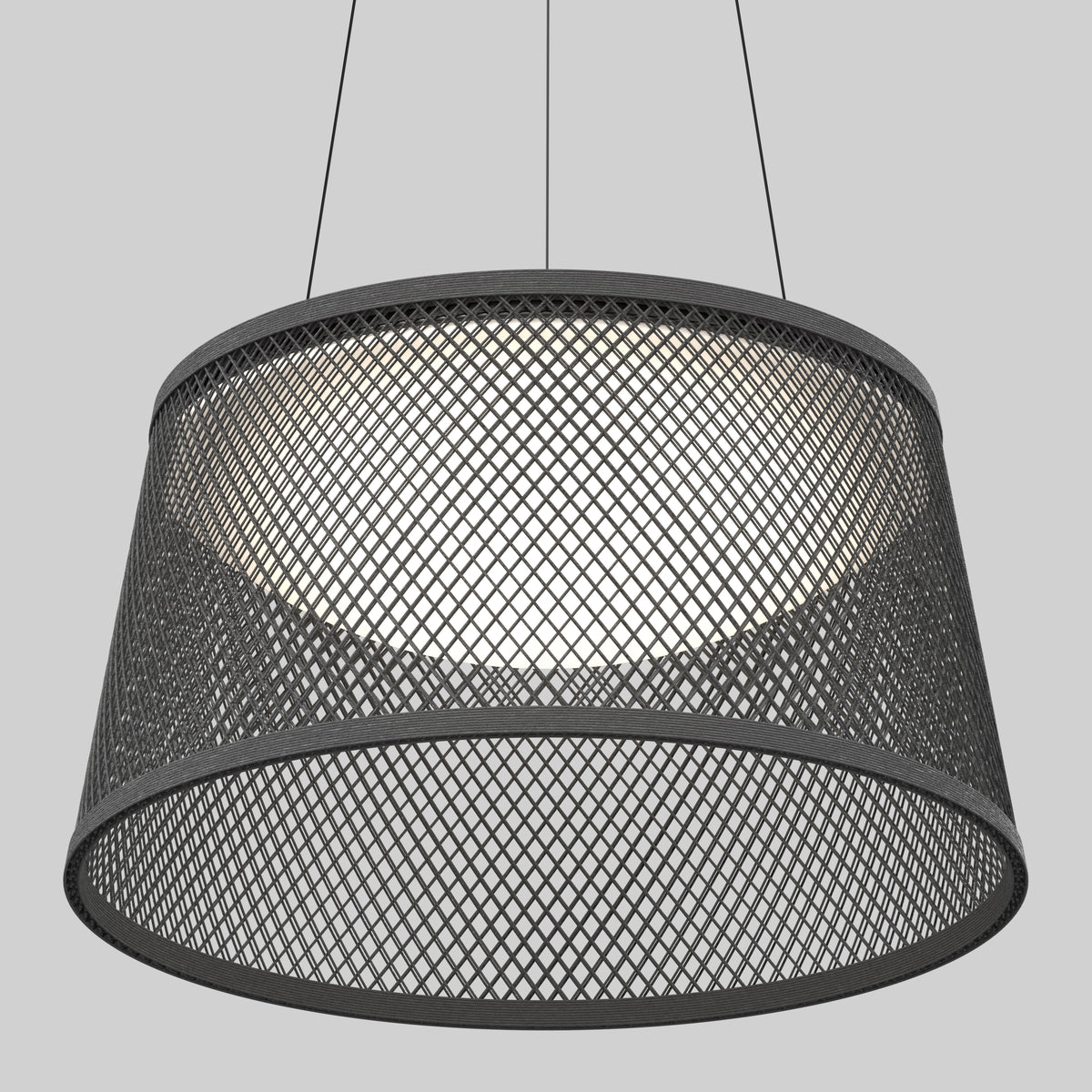 A modern pendant light with a wide, black metal mesh shade, suspended by two thin cables against a plain gray background. The light inside creates a soft glow through the mesh pattern.