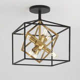 A modern ceiling light fixture with exposed bulbs, featuring intersecting black and gold geometric metal frames in a cube shape, mounted on a white ceiling.