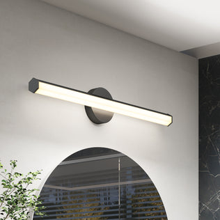 The Artika Ewen modern LED bathroom vanity light 5 CCT shines above a rounded mirror, lighting a white wall with black and green decor.
