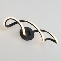 The Artika Swirl LED bathroom vanity light features two curved black metal arms outlined with warm white LEDs, mounted on a circular black base against a light gray wall.