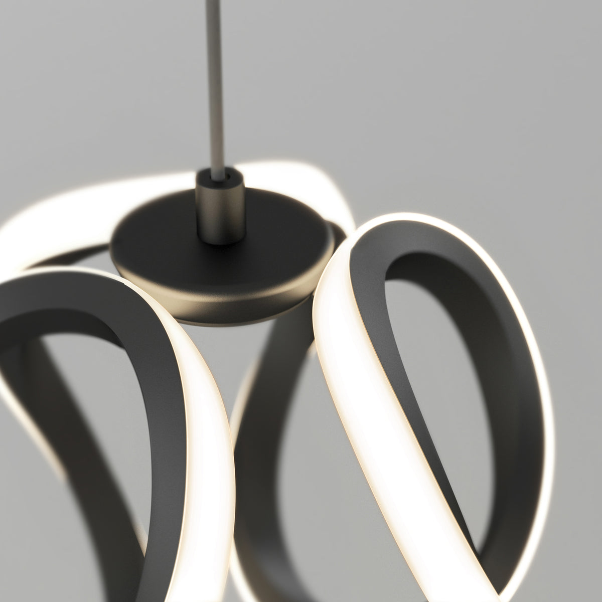 A modern pendant light fixture with intertwined, glowing LED loops and a central black circular base, suspended from the ceiling against a plain gray background.