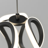 A modern pendant light fixture with intertwined, glowing LED loops and a central black circular base, suspended from the ceiling against a plain gray background.