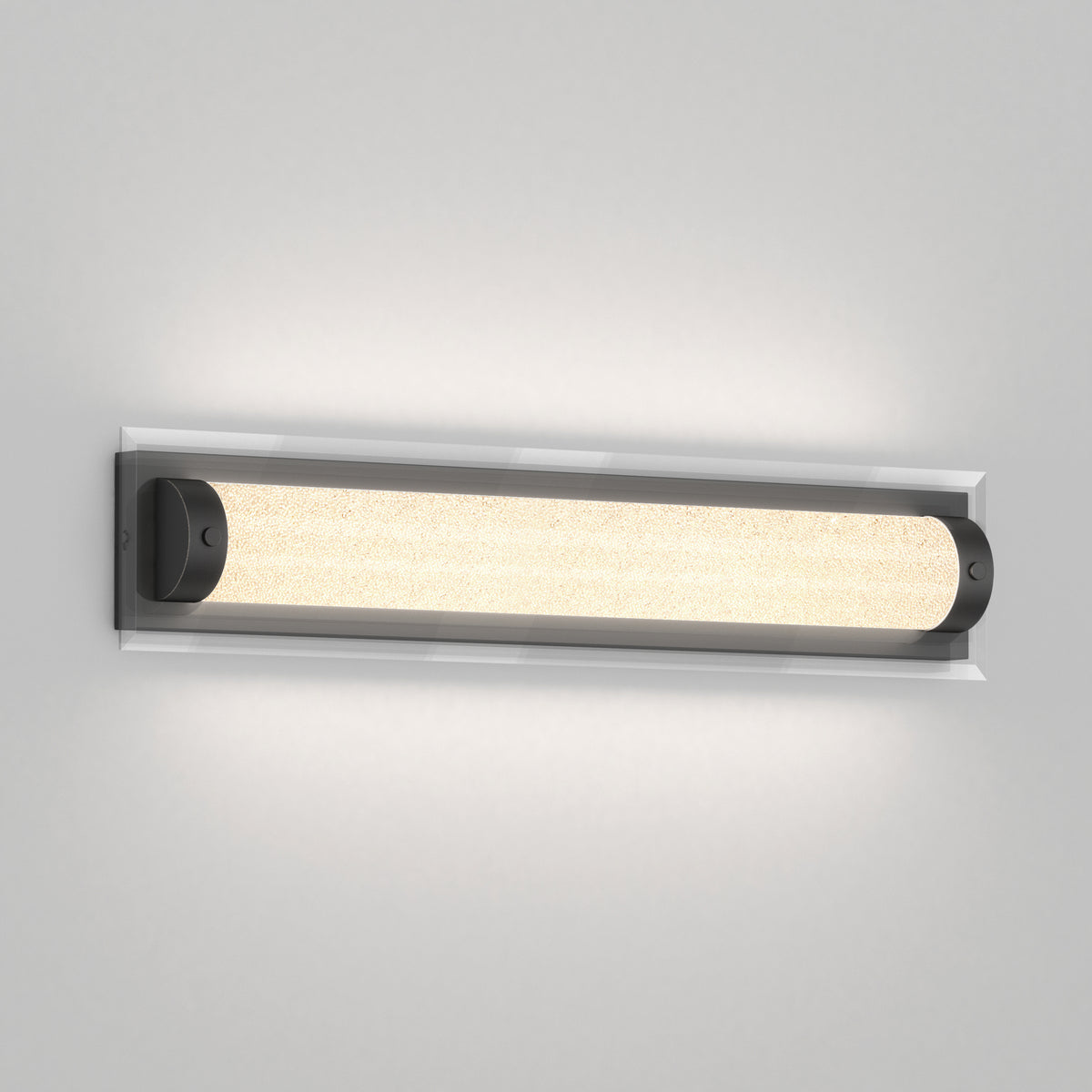 A modern wall-mounted light fixture with a long, cylindrical frosted glass shade and dark end caps, emitting a soft, even glow against a light gray wall.