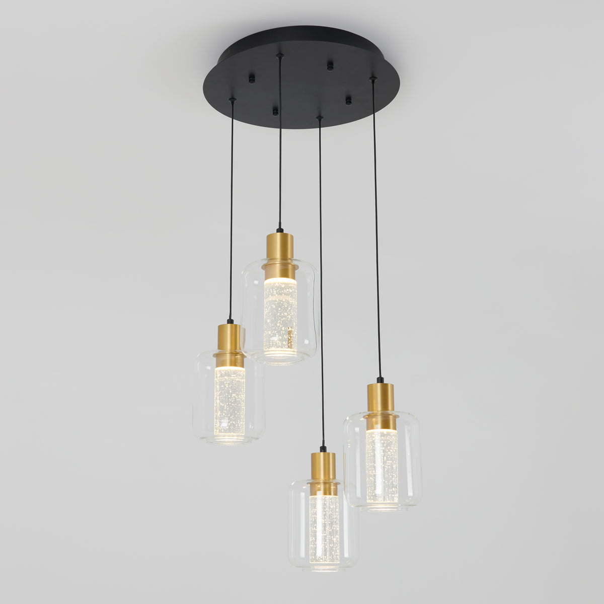 The Artika Champagne Globe 4-light LED pendant features four gold and clear glass lamps suspended at varying heights from a round black mount for a modern ceiling lighting look.