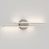Modern wall sconce with two parallel horizontal LED light bars extending from a round metallic base, casting soft light against a plain, light-colored wall.