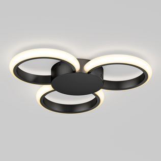 The Artika Nyala 15 in. LED flush mount light 5CCT features three interlocking black rings with glowing white LEDs, all mounted on a round black base and shown against a plain gray background.