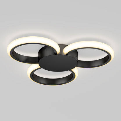 The Artika Nyala 15 in. LED flush mount light 5CCT features three interlocking black rings with glowing white LEDs, all mounted on a round black base and shown against a plain gray background.