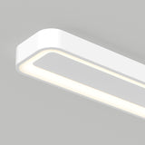 A close-up view of a modern, rectangular white ceiling light fixture with rounded edges, emitting a soft, even glow against a light gray background.