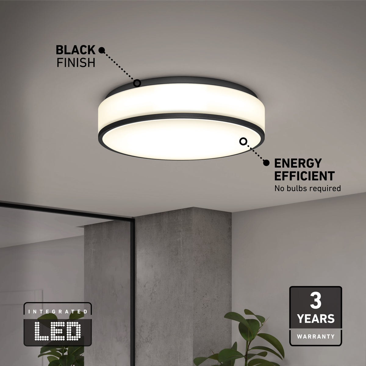 A round, modern ceiling light with a black finish is mounted on a white ceiling. Highlights include energy efficiency, integrated LED, and a 3-year warranty. A plant and a mirror are partially visible in the room below.