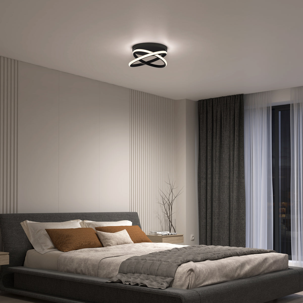 A modern bedroom with a low-profile gray bed, neutral bedding, and brown accent pillows. A unique, circular ceiling light illuminates the room, which features minimalist décor, a large window with dark curtains, and soft wall paneling.