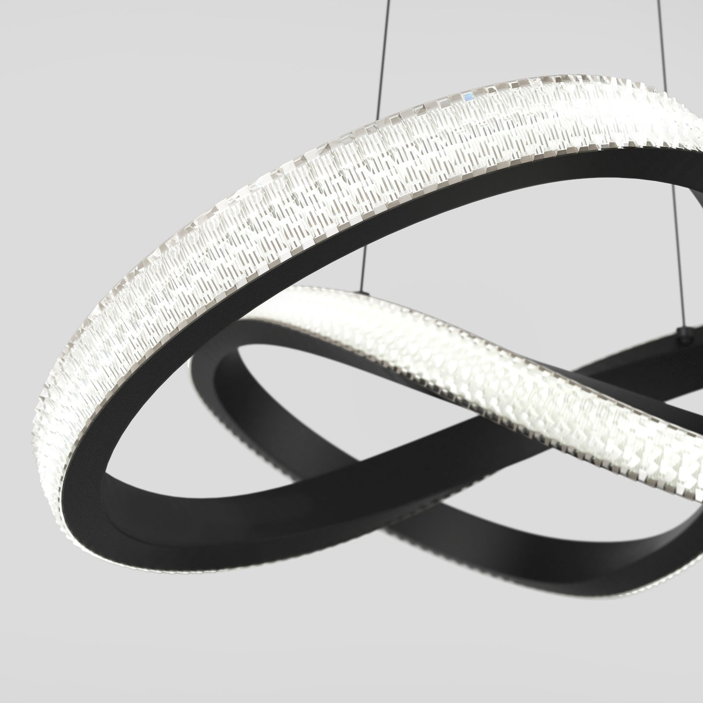The Artika Morgan LED contemporary pendant light features two intersecting black rings with textured, illuminated edges, suspended by thin wires against a light gray background.