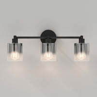 The Artika Haze modern 3-light bathroom vanity light features three exposed bulbs in clear cylindrical glass shades, shown mounted on a light gray wall.
