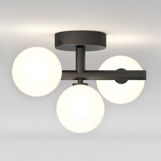 The Artika Bloom LED flush mount features three white glass globes, tunable white tech, and a matte black base for modern ceilings.