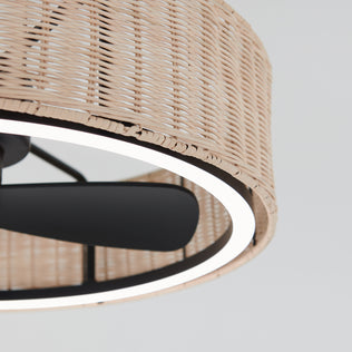 Close-up of the Artika Kalani 24 in. LED modern ceiling fan with black blades, a round wicker frame, illuminated LED ring, and remote control, set against a light background.