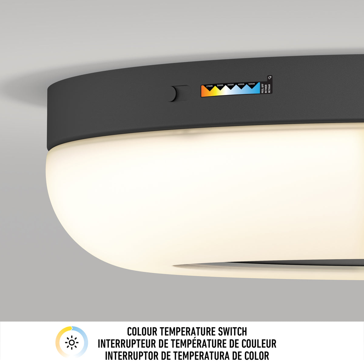 A close-up of a ceiling light fixture with a visible color temperature switch displaying multiple color options. Text below reads: Colour temperature switch in English and French.