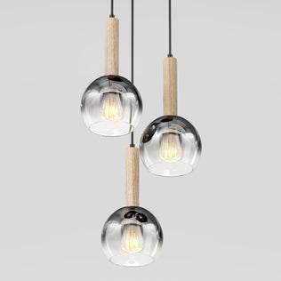 The Ardel Spiral 3-Light Pendant by Artika features clear glass globes, wooden accents, and hangs from black cords against a plain light background; bulbs not included.