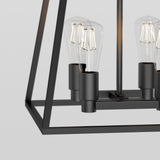 Close-up of a modern black metal chandelier with exposed vintage-style bulbs, featuring a geometric open frame design against a plain light background.