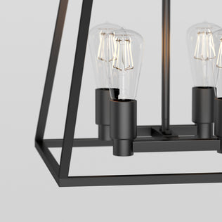 Close-up of the Artika Carter Square 4-light chandelier with exposed Edison bulbs set against a light background.
