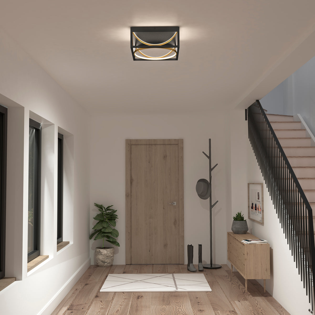 A modern, minimalist entryway with a wooden door, potted plant, coat rack with hats, bench with decor, staircase with black railing, three windows, boots by the door, and a geometric ceiling light.