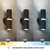 Three identical cylinder wall lights are shown on textured walls, each emitting different color temperatures: warm white (3000K), neutral white (4000K), and cool white (5000K). A color temperature scale is displayed below.