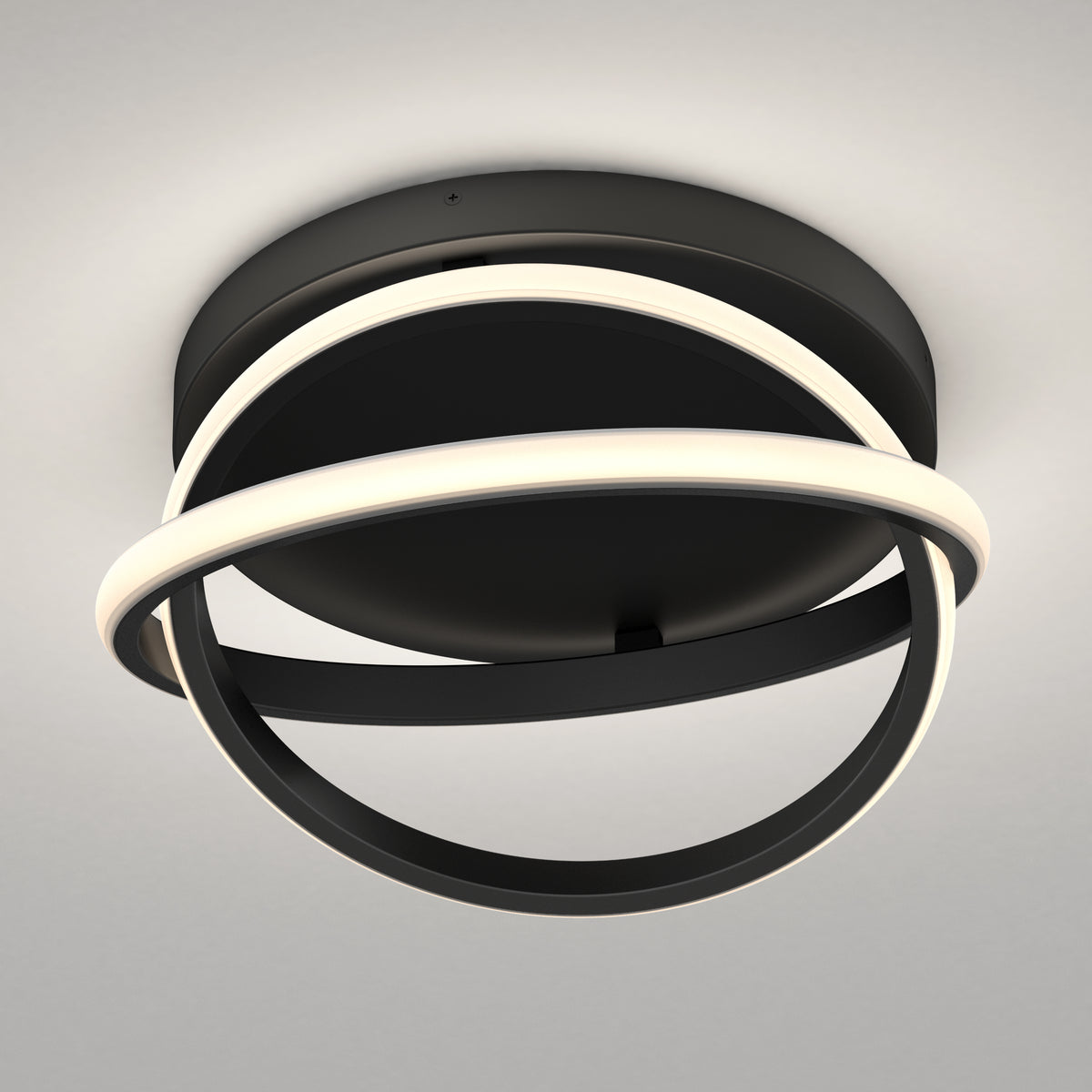 A modern ceiling light fixture with two intersecting black rings, each partially illuminated by integrated LED strips, mounted on a round black base against a light-colored ceiling.
