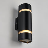 A modern black wall sconce with a cylindrical shape, featuring two horizontal slits near the top and bottom that emit soft, warm white light, mounted on a light gray wall.