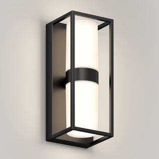The Artika Sherman modern LED indoor-outdoor wall light 5 CCT features a rectangular black metal frame and cylindrical white frosted glass shade, shown mounted on a light gray wall.