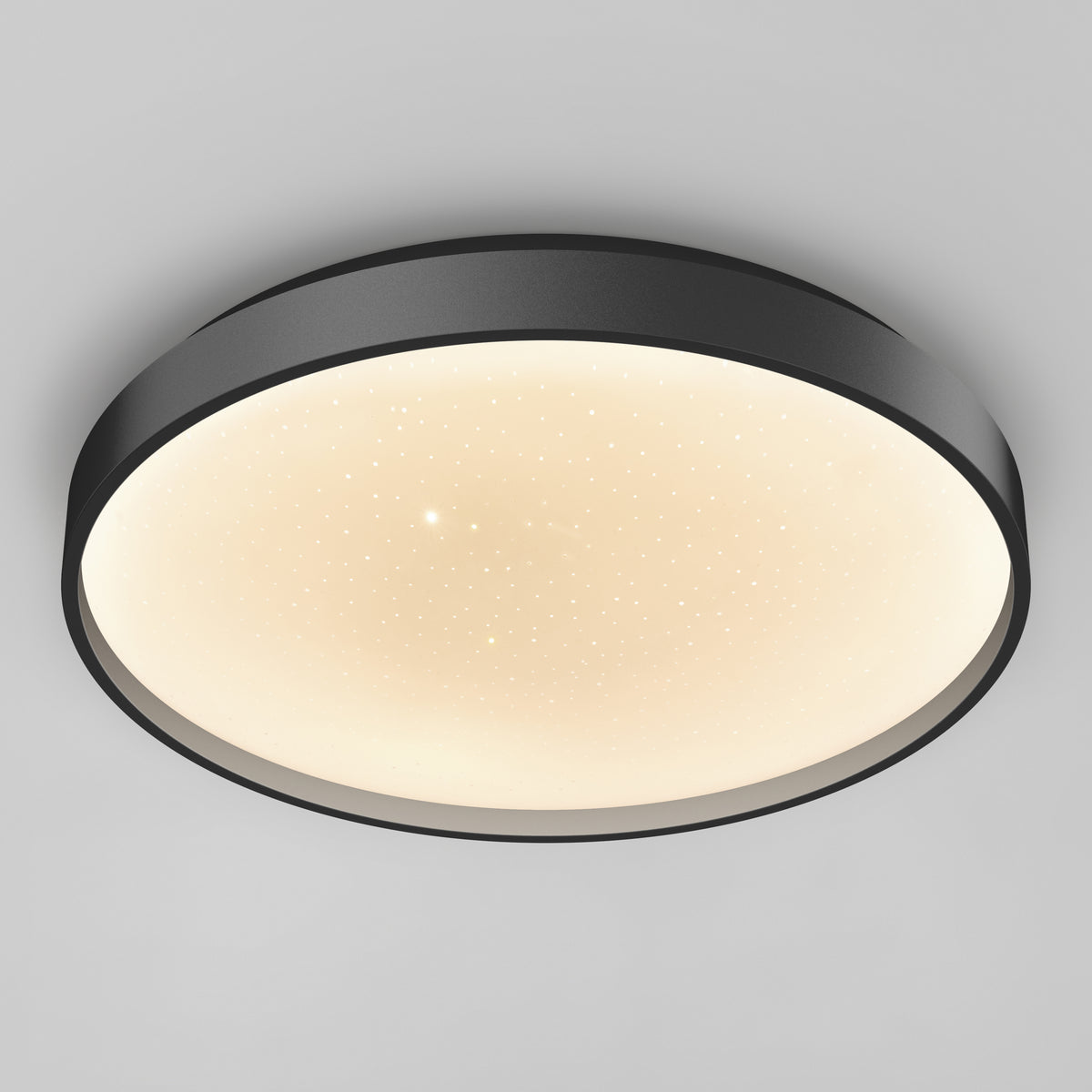 A modern, circular ceiling light with a dark outer rim and a glowing white center, featuring small, subtle dots that create a starry effect on its surface.