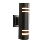 A modern black cylindrical wall sconce with horizontal cut-out slots emitting warm light, mounted on a rectangular backplate.