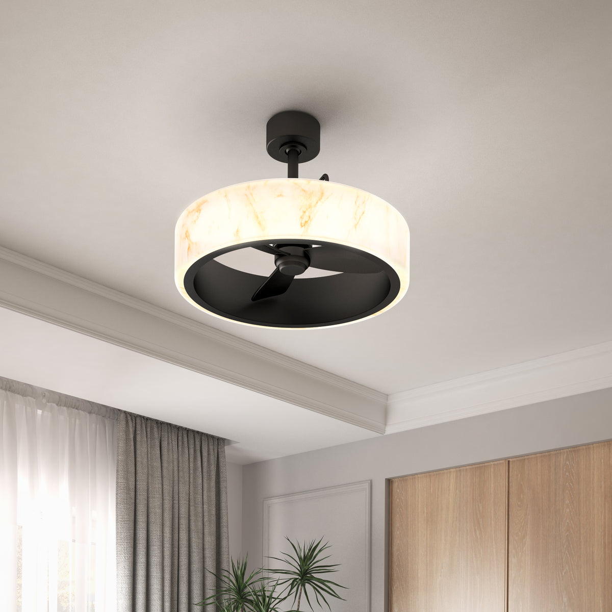 A modern ceiling fan with a circular, marble-patterned light fixture and black blades, mounted on a white ceiling in a contemporary room with large windows, curtains, plants, and wooden cabinets.