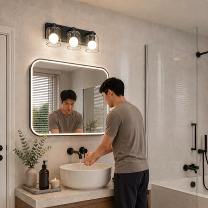 Man washing hands at a sink, with an Artika Aryna 20 in. 3-Light LED Vanity above the mirror and a bathtub in the background.