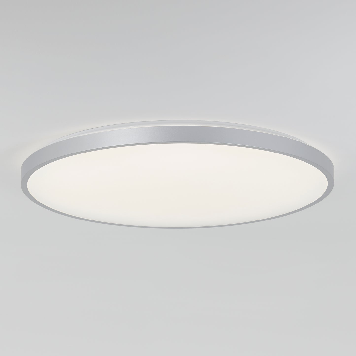 The Artika Europa 21 in. LED modern flush mount light features a flat white diffuser and metallic silver rim, seamlessly mounted on a plain white ceiling. Includes remote control for added convenience.