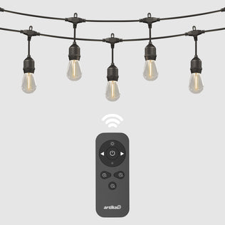 The Eclipse Solar String Light with Remote by Artika features five hanging bulbs and comes with a black remote control for power, brightness, and timer settings. A wireless icon highlights its convenient remote operation.