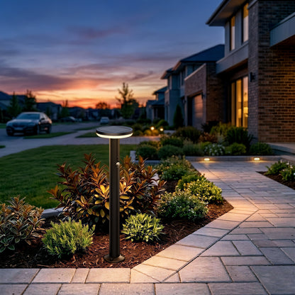 Modern home at sunset with Artika Urbia Solar LED Bollards lighting the landscaped yard and stone walkway.