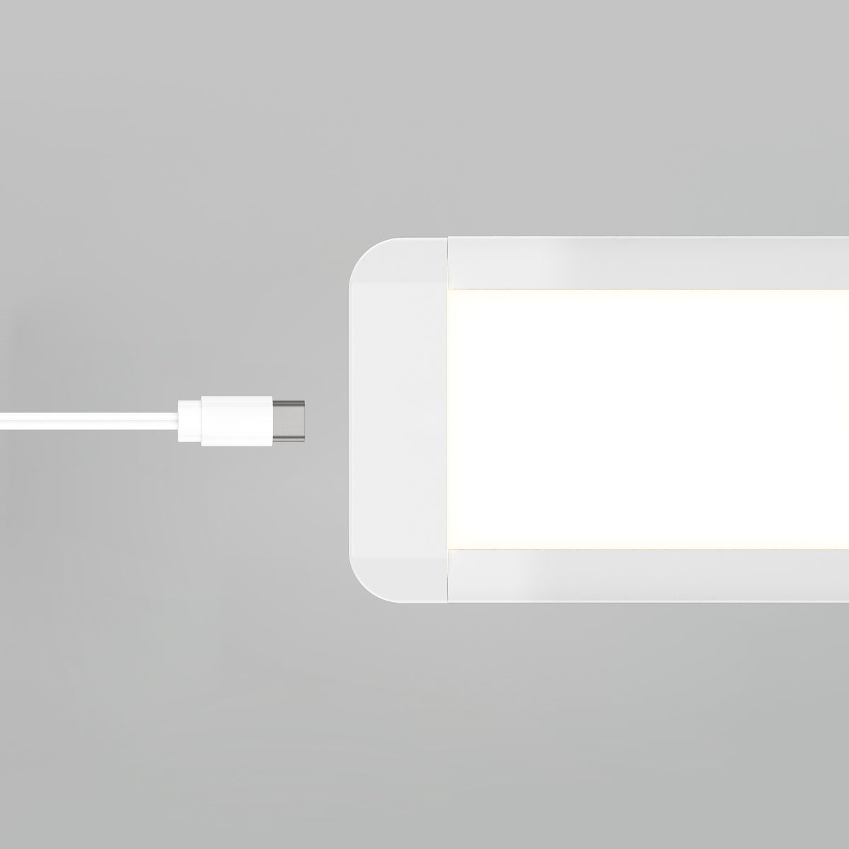 A white USB-C cable is positioned near the port of the Artika Maestro under cabinet LED light 3CCT, a rectangular white device, on a light gray background.
